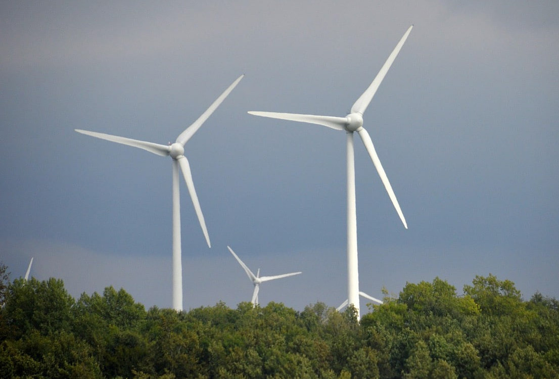 Stora vindkraftverk tornar upp sig mot himlen.